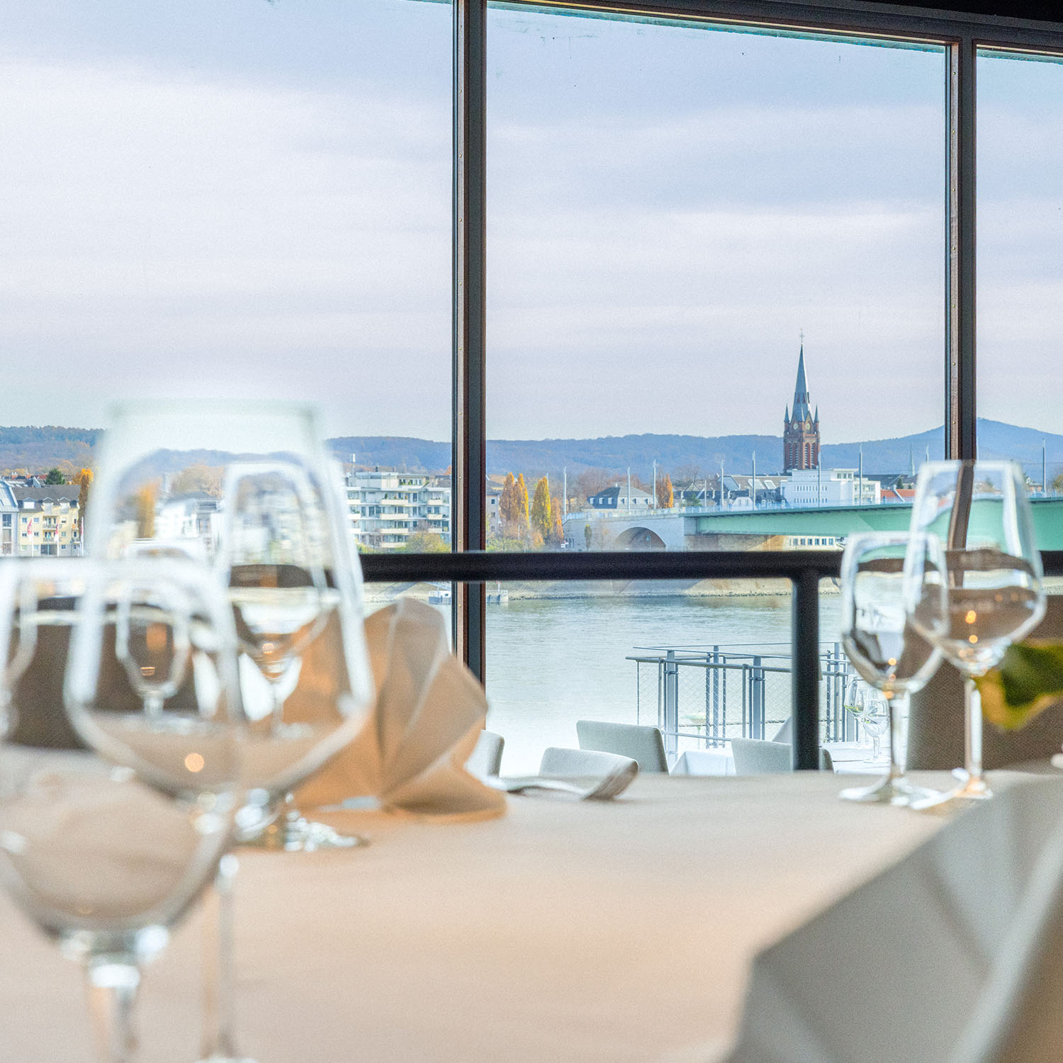 Tisch am Fenster mit Weingläsern und Blick auf den Rhein